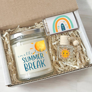 Gift set with a candle labeled 'Smells like Summer Break' and a small bottle with a rainbow design.